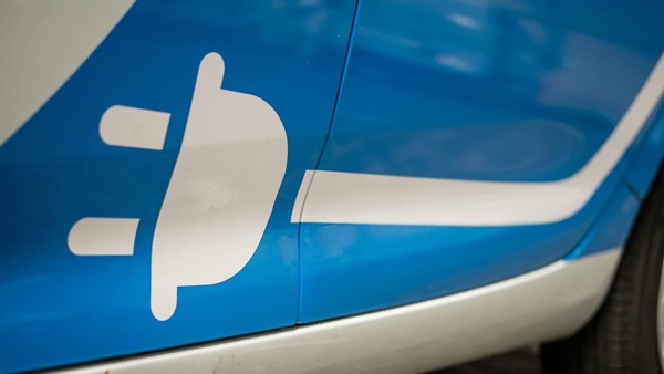 elektrische aangedreven Personeel Ophaal Dienst-auto wit stekkerlogo (elektrisch aangedreven) op de zij-onderkant van een blauw-witte Arriva Personeel Ophaal Dienst-auto