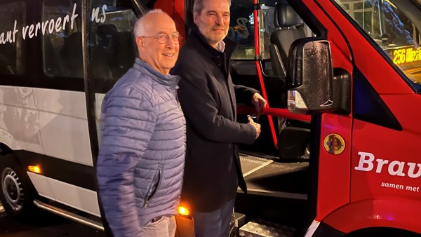 Wethouder Henri Willems en chauffeur Jan Verbruggen stappen in een rood-witte Arriva buurtbus. Wethouder Henri Willems en chauffeur Jan Verbruggen stappen in een rood-witte Arriva buurtbus.