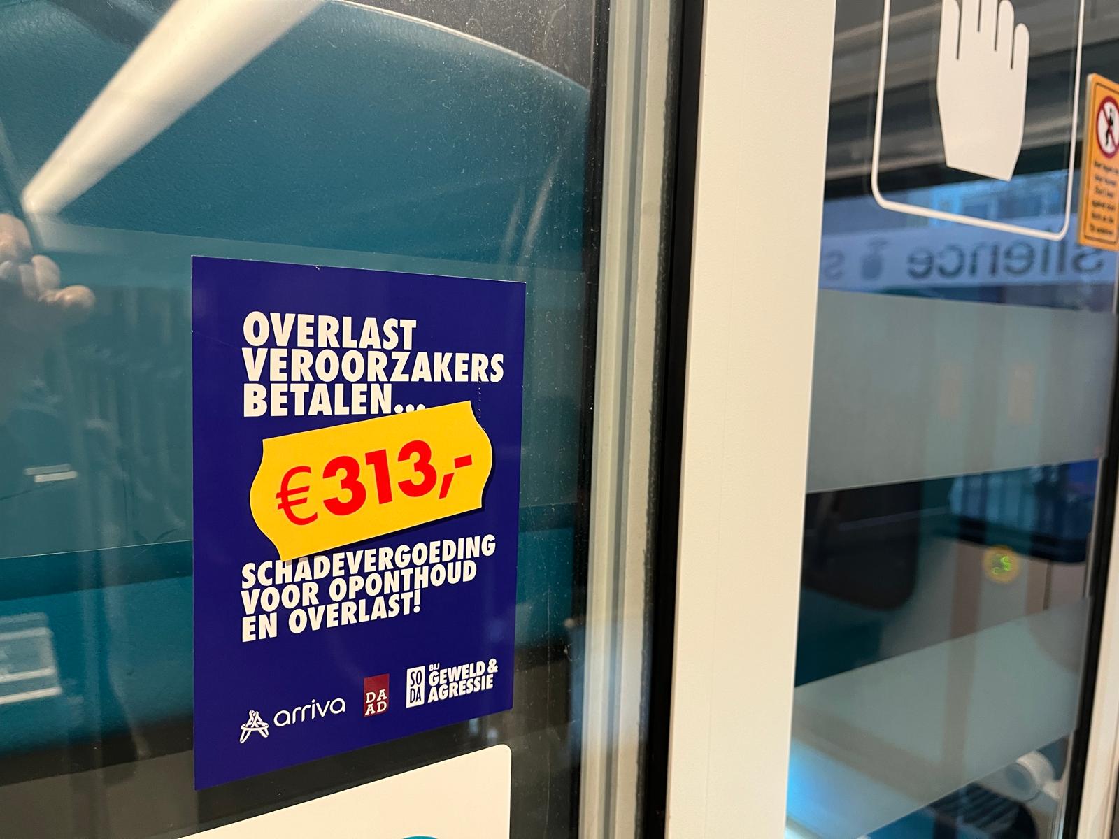 Donkerblauw SODA poster in de trein met daarop de tekst 'overlastveroorzakers betalen 313 euro schadevergoeding