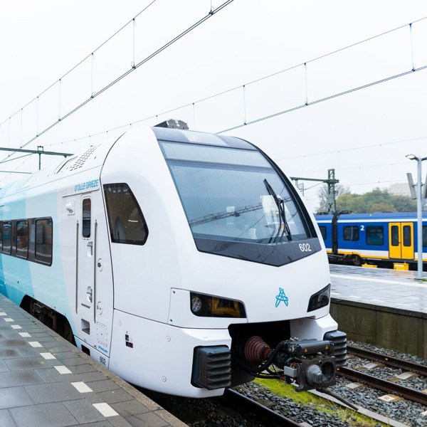Een blauwe trein staat aan het verregende perron van station Groningen. Een blauwe trein staat aan het verregende perron van station Groningen.