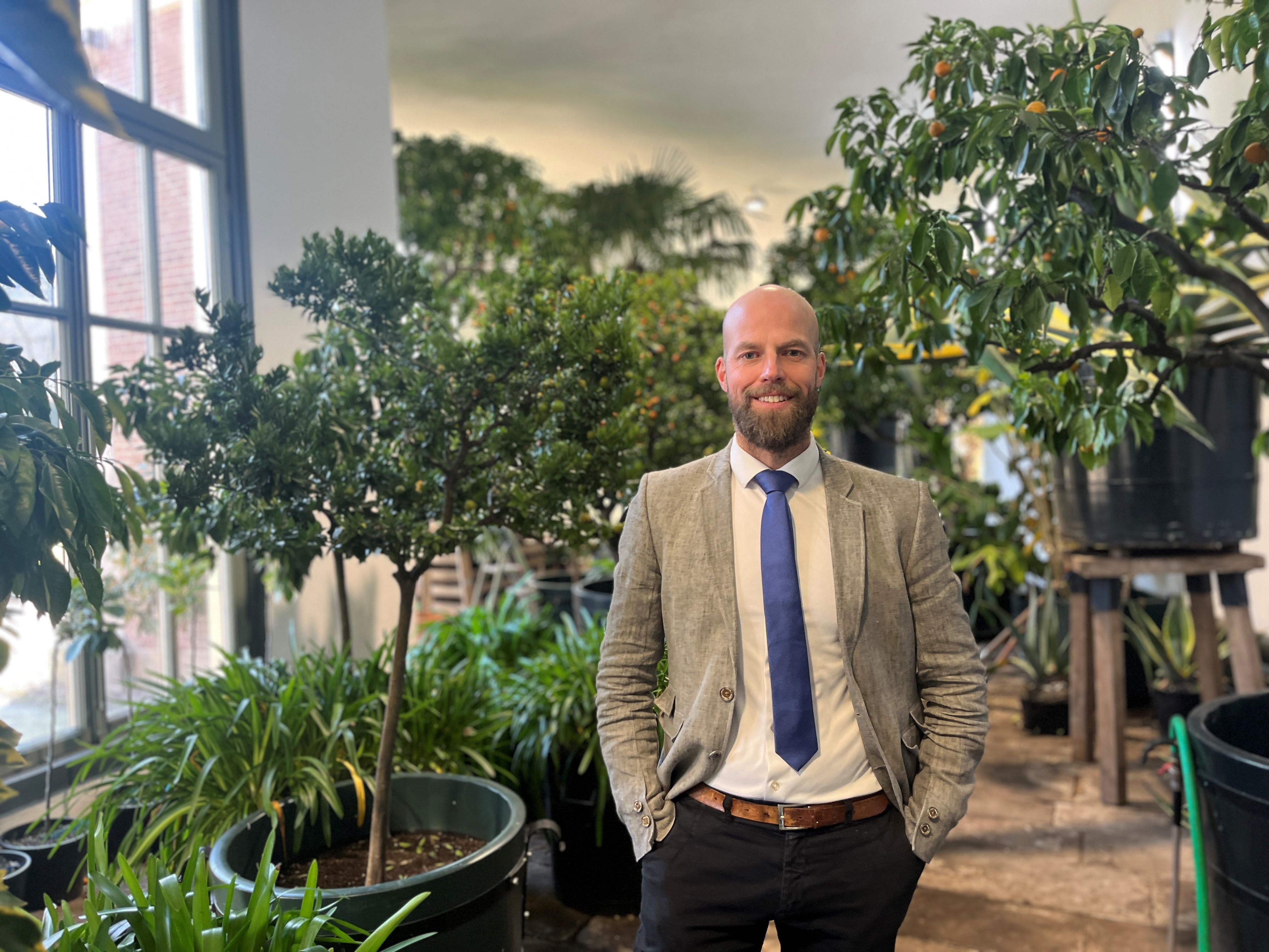 Rentmeester Mooiweer van Landgoed Twickel staat in de oranjerie voor sinaasappelbomen trots en met een glimlach