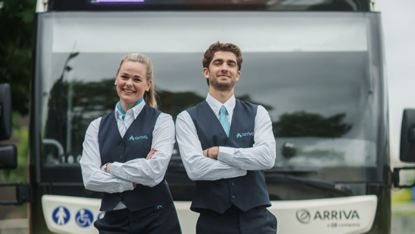 Twee chauffeurs in hun Arriva-uniform staan lachend voor een bus met lijnnummer 1 en Arriva erop. Twee chauffeurs in hun Arriva-uniform staan lachend voor een bus met lijnnummer 1 en Arriva erop.
