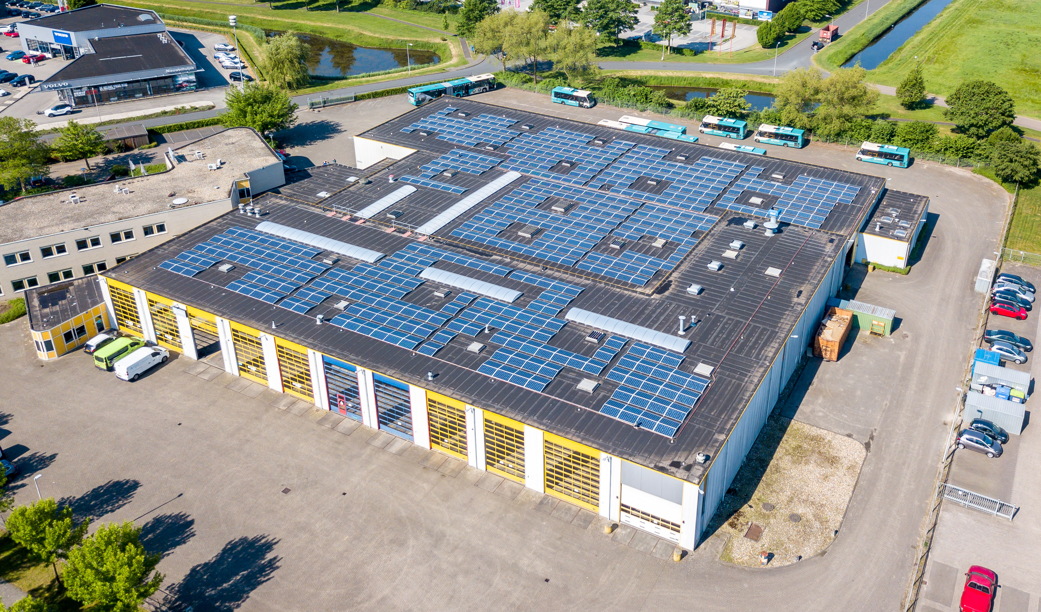 Een bovenaanzicht van een Arriva-busremise met zonnepanelen op het dak.