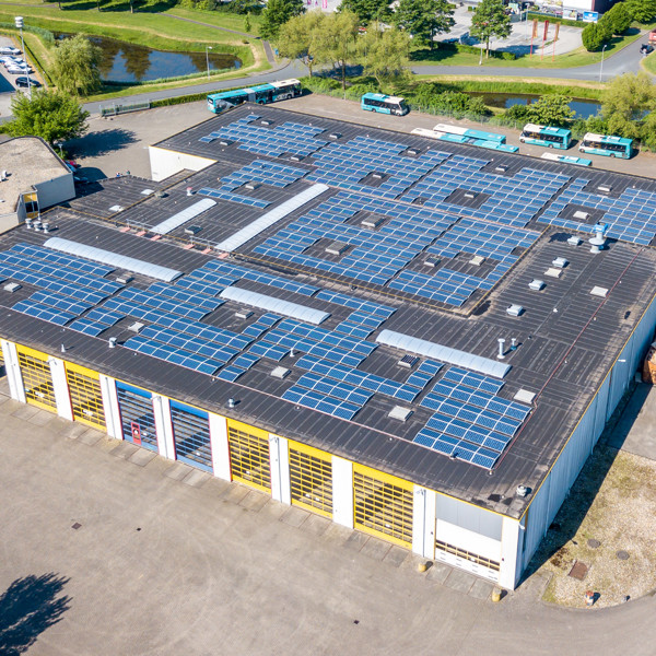 Een bovenaanzicht van een Arriva-busremise met zonnepanelen op het dak. Een bovenaanzicht van een Arriva-busremise met zonnepanelen op het dak.
