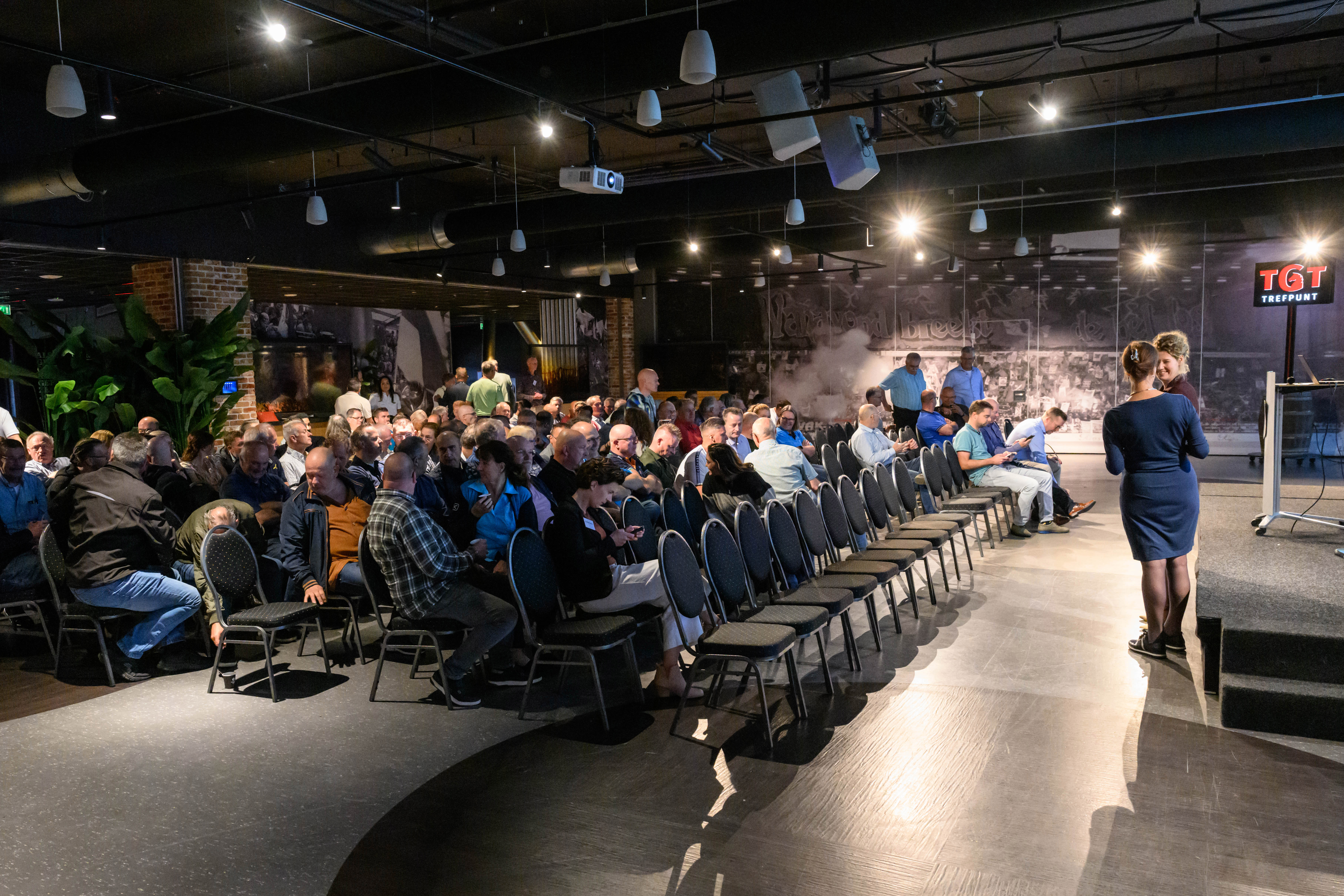 Een zaal gevuld met zo'n 150 mensen aan publiek.