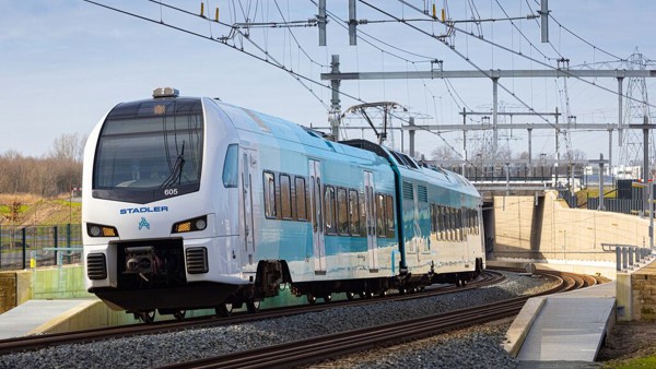 Een blauw-witte Arriva-trein rijdt over het spoor onder een blauwe lucht. Een blauw-witte Arriva-trein rijdt over het spoor onder een blauwe lucht.