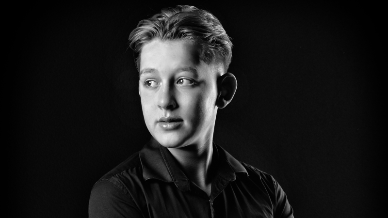 Reiziger Mathieu staat met een zwart wit foto in de trein De Tukker Reiziger Mathieu staat met een zwart wit foto in de trein De Tukker