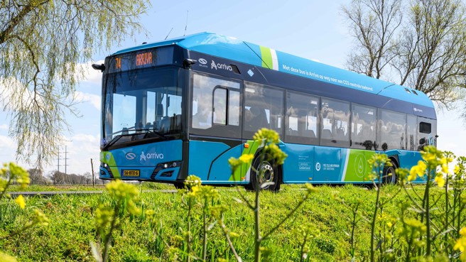 Een blauwe Arriva-waterstofbus rijdt over de weg in een groene omgeving. Een blauwe Arriva-waterstofbus rijdt over de weg in een groene omgeving.