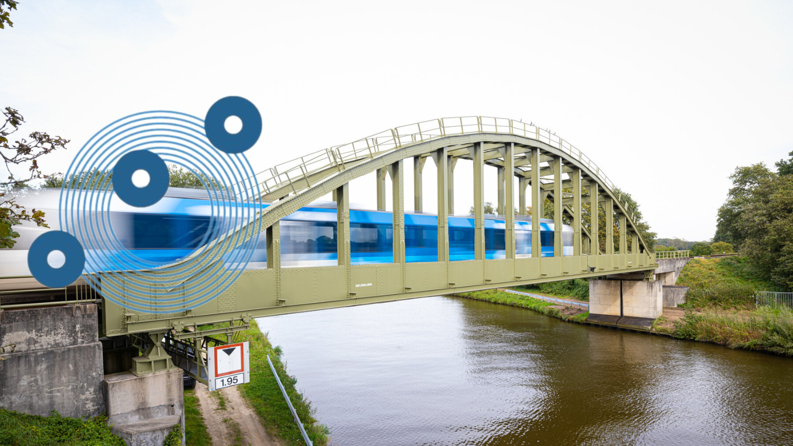 Blauwnet trein  rijdt over een brug tussen Zutphen Hengelo en Oldenzaal. 