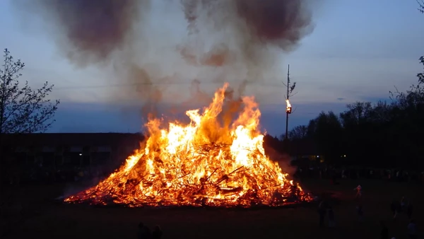 Een schemeravond waar je een aangestoken paasvuur ziet met rook Een schemeravond waar je een aangestoken paasvuur ziet met rook