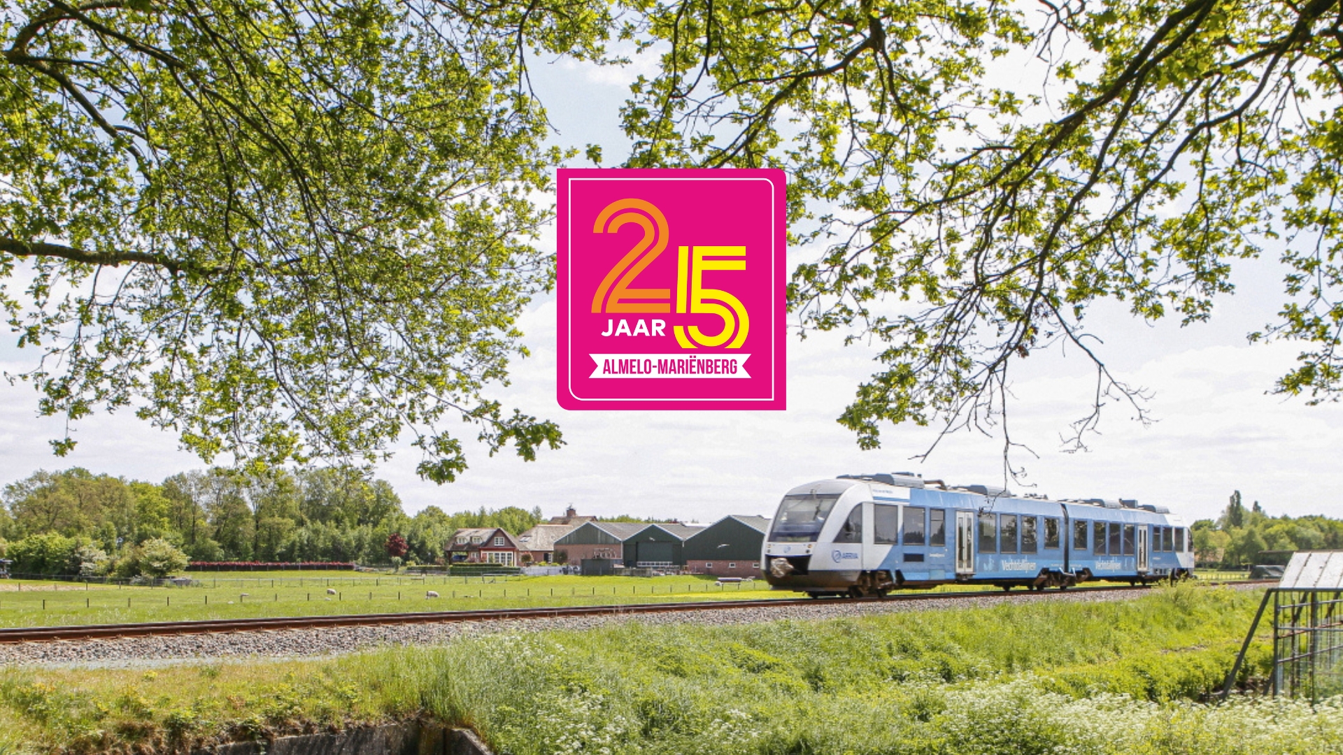 Een Arriva-trein rijdt over het spoor in een groene omgeving, met een afbeelding op de foto waarop de tekst "25 jaar Almelo-Mariënberg" staat. Een Arriva-trein rijdt over het spoor in een groene omgeving, met een afbeelding op de foto waarop de tekst "25 jaar Almelo-Mariënberg" staat.