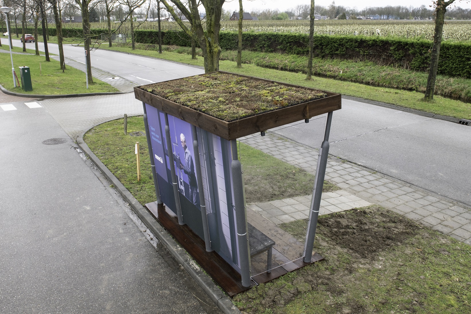 De nieuwe haltezitter - een bushalte met 5 zitplaatsen - gemaakt van gebruikte materialen en een sedum dak. Van bovenaf gefotografeerd.