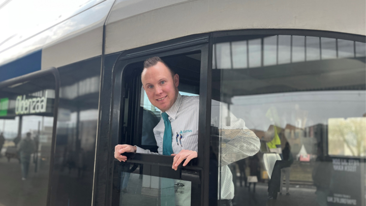 Machinist Alex hangt lachend uit het raam van een Blauwnettrein Machinist Alex hangt lachend uit het raam van een Blauwnettrein