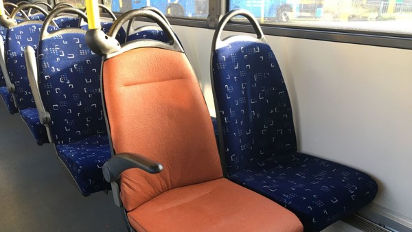 Een stoel in een bus in Friesland met bekleding van oranje fruitleer.