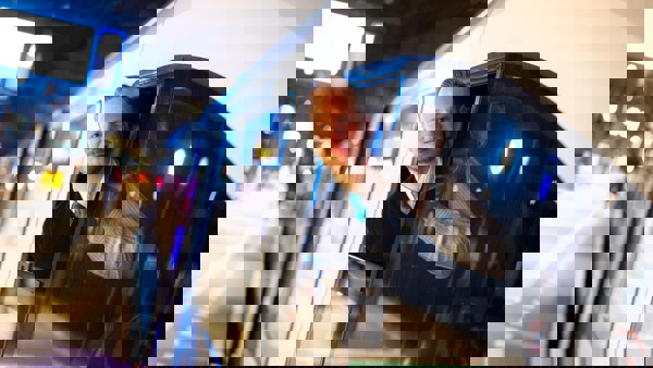 Machinist kijkt lachend vanuit cabine Machinist kijkt lachend vanuit cabine