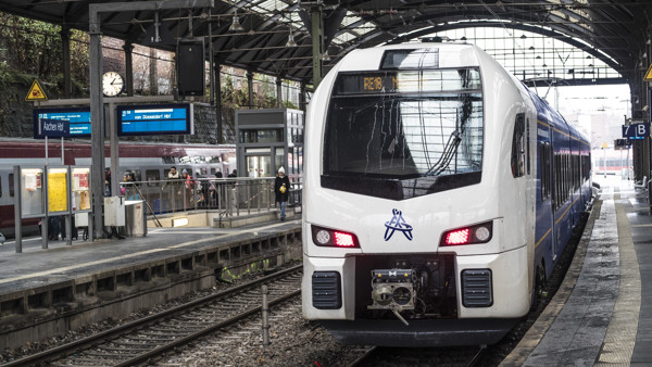 Blauw witte Arriva Drielandentrein staat met gesloten deuren klaar aan het perron van station Aken om in de richting van Maastricht-Luik te vertrekken.