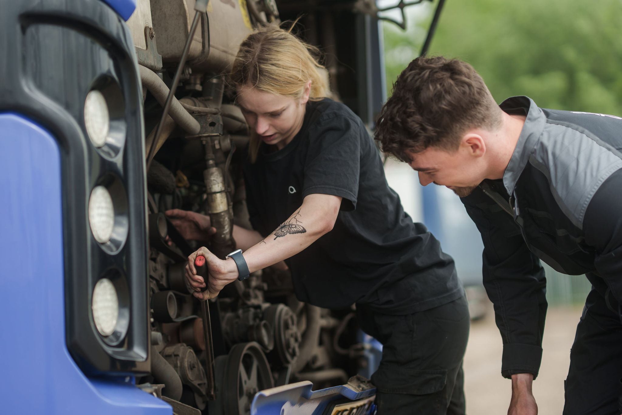 Twee monteurs van Arriva sleutelen samen aan de motor van een bus