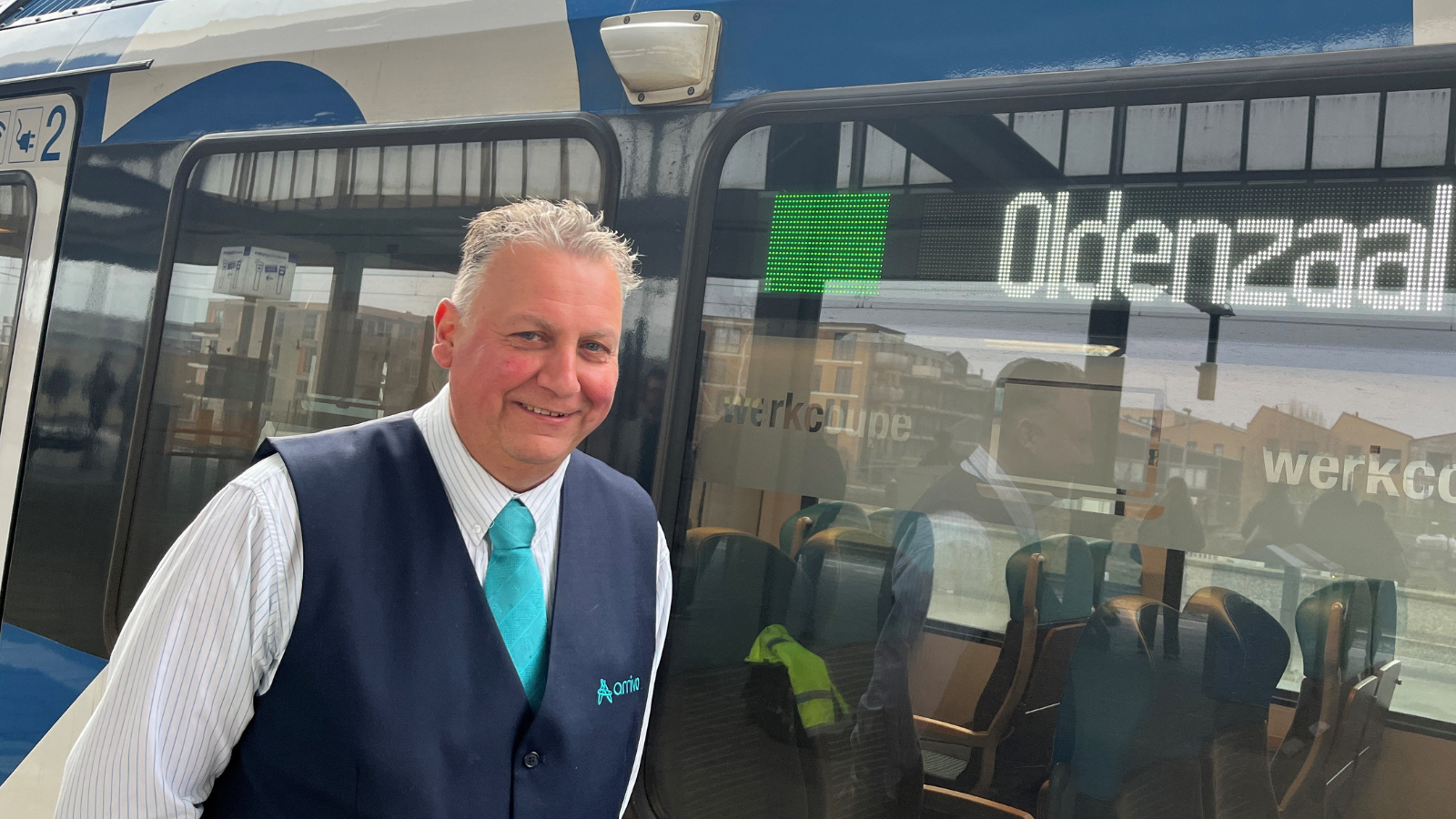 Machinist Henk staat met een glimlach trots voor zijn Blauwnettrein