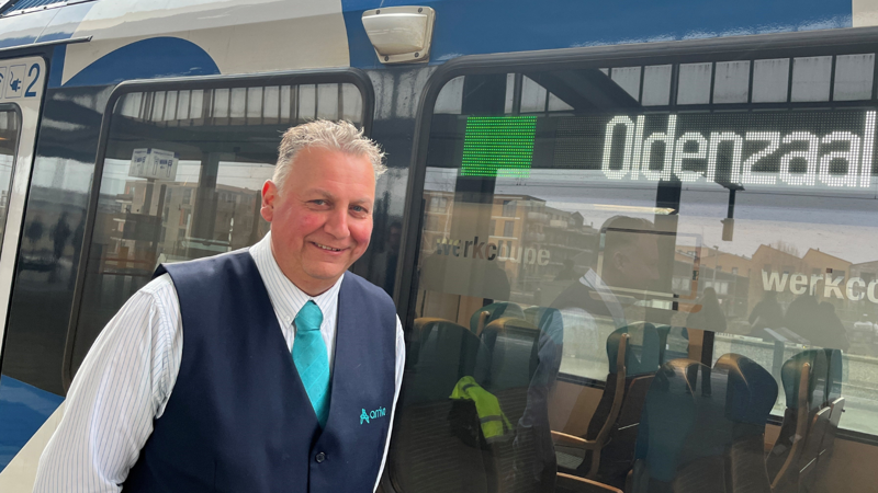 Machinist Henk staat met een glimlach trots voor zijn Blauwnettrein Machinist Henk staat met een glimlach trots voor zijn Blauwnettrein