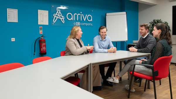 Vier jonge collega's van Arriva vergaderen in een ruimte met Arriva op de wand en een flipboard op de achtergrond. Vier jonge collega's van Arriva vergaderen in een ruimte met Arriva op de wand en een flipboard op de achtergrond.