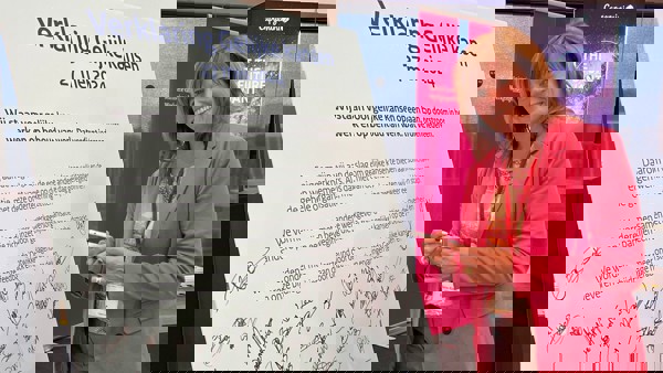 Manager Talent, Ontwikkeling & Recruiment ondertekent namens Arriva Nederland de Verklaring Gelijke Kansen Dame in rose jasje ondertekent glimlachend namens Arriva Nederland de Verklaring Gelijke Kansen